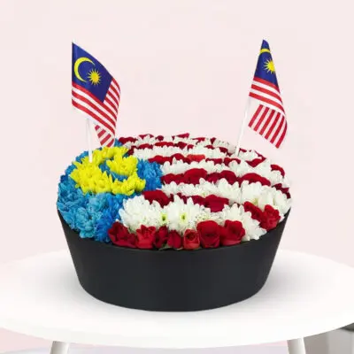 A vibrant flower arrangement featuring the colors and design of the Malaysian flag, showcasing red, blue, yellow, and white blooms.