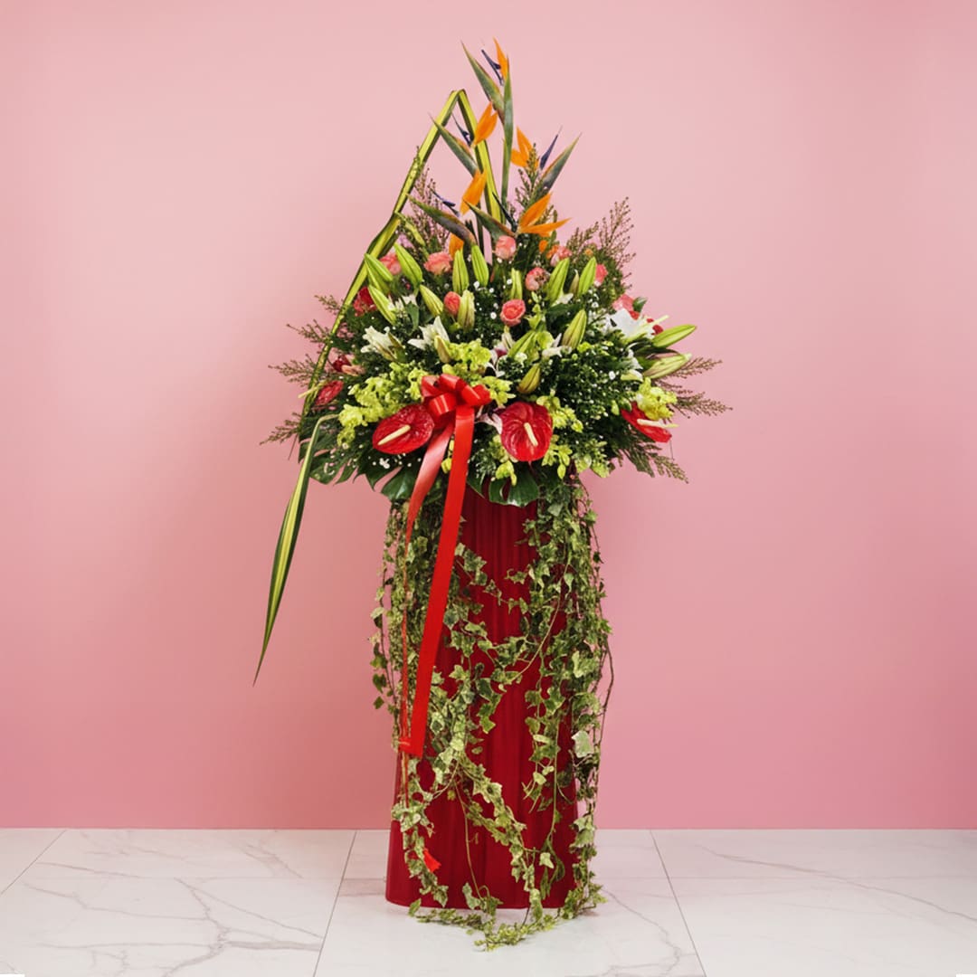 Radiant Floral Stand-02-301 A large floral arrangement featuring 15 roses, 10 lilies, and 5 anthuriums in a red vase for a grand opening stand.