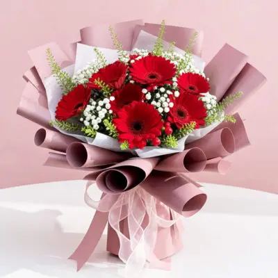 A vibrant bouquet of red gerbera flowers accented with delicate baby's breath.