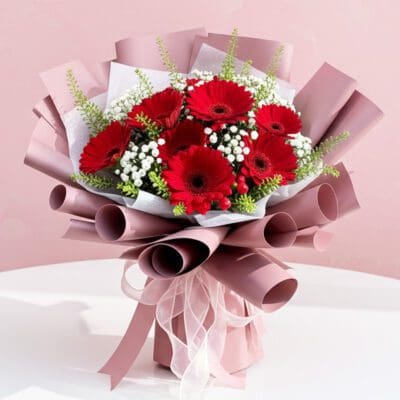 A vibrant bouquet of red gerbera flowers accented with delicate baby's breath.