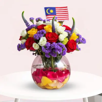A vase filled with colorful flowers alongside a small Malaysian flag, symbolizing national pride and beauty.