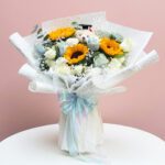 A Cheerful Arrangement Of Sunflowers And White Roses, Symbolizing Blossom Bliss Graduation.