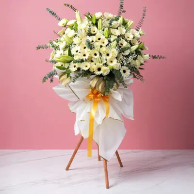 A stand displaying a white flowers for sympathy and funerals