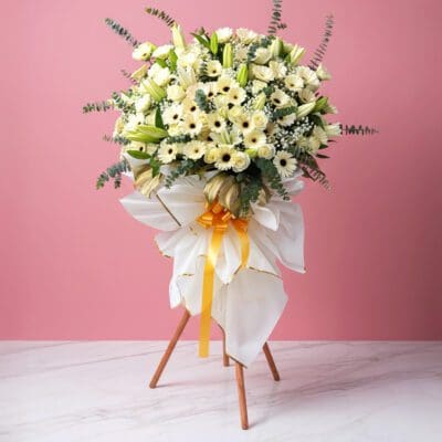 A stand displaying a white flowers for sympathy and funerals