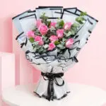 A lush hand bouquet featuring 10 pink roses, representing fresh beginnings and conveying a sense of tranquility and elegance.
