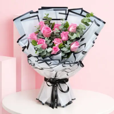 A lush hand bouquet featuring 10 pink roses, representing fresh beginnings and conveying a sense of tranquility and elegance.