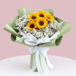 A vibrant bouquet featuring bright sunflowers surrounded by delicate sprigs of baby's breath.
