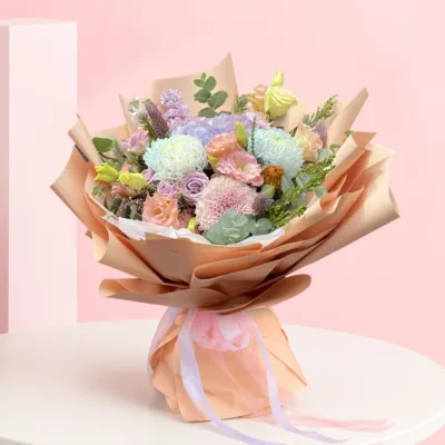 A colorful bouquet of flowers arranged in a paper bag, placed on a wooden table.