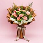 A vibrant bouquet of roses tied with a ribbon, set against a soft pink background.
