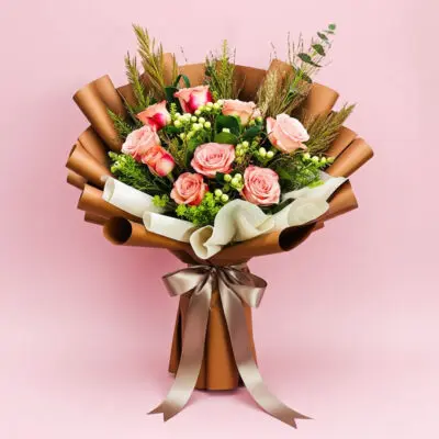A vibrant bouquet of roses tied with a ribbon, set against a soft pink background.