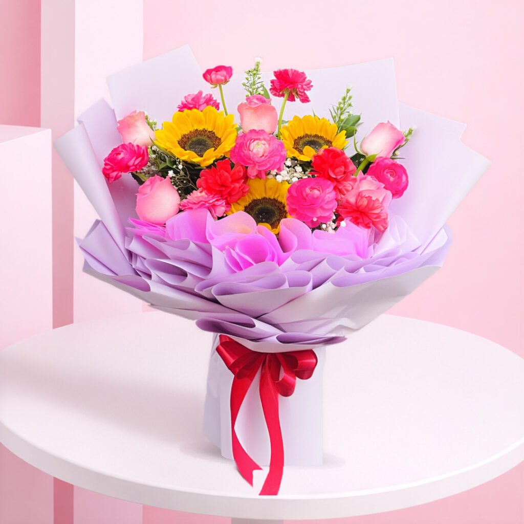 An enchanting bouquet of radiant sunflowers and delicate pink roses, expertly wrapped and finished with an elegant ribbon.