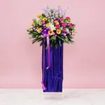 A large purple vase adorned with colorful flowers, showcasing a vibrant floral arrangement.