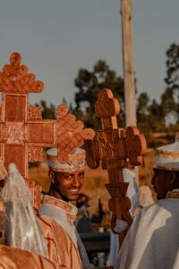 A vibrant scene at a Meskel celebration. People are gathered together, some carrying colorful crosses and flags. The atmosphere is festive and joyful, with music and dancing likely taking place. The image captures the spirit of this Ethiopian Orthodox Christian holiday.