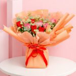 A charming bouquet of peach roses presented in a stylish