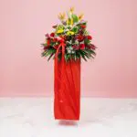 A Cheerful Arrangement Of Yellow And Red Daisies In A Red Color, Displayed On A Pink Background, Ideal For Festive Occasions.