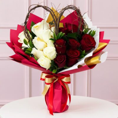 A bouquet of red and white roses arranged in a matching red and white vase.
