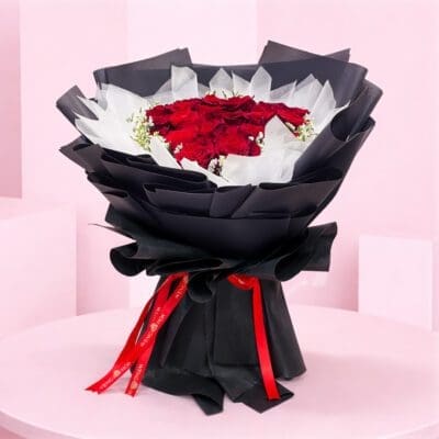 A vibrant bouquet of red roses surrounded by delicate white baby's breath flowers.