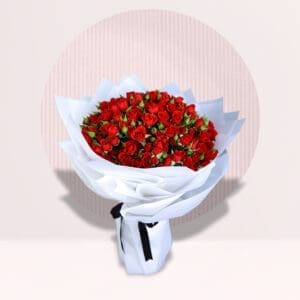 A large bouquet of 101 red roses is tightly wrapped in white paper and tied