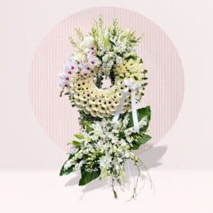 Floral Wreath: The arrangement features a circular wreath at the top, made of white flowers, possibly daisies, gerbera daisies, or chrysanthemums.