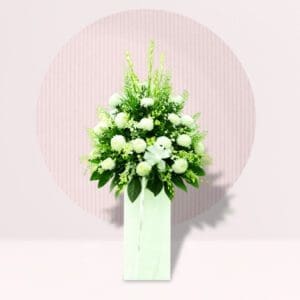 White Flowers: The arrangement predominantly features white flowers, including what appear to be chrysanthemums or similar rounded blooms. White is often associated with purity, peace, and remembrance.