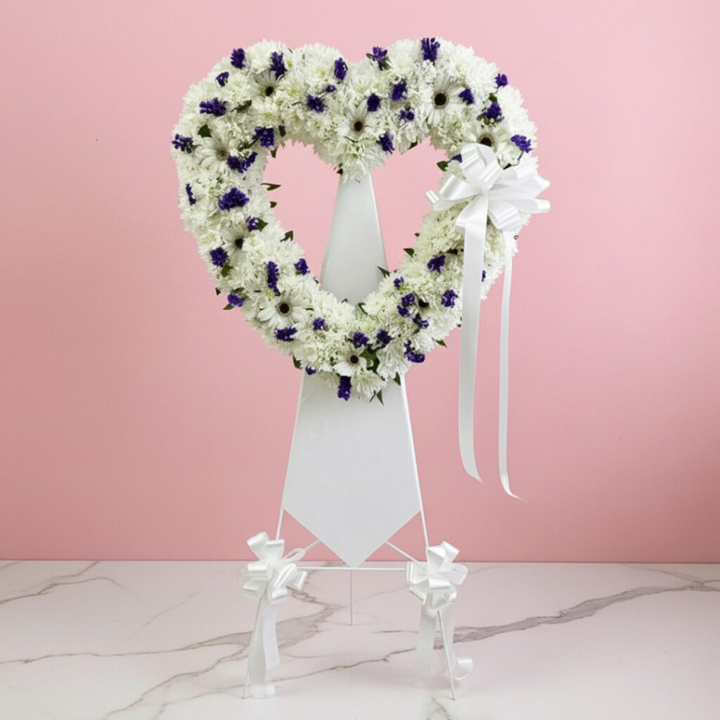 Heart-shaped wreath adorned with purple and white flowers, symbolizing love and beauty.