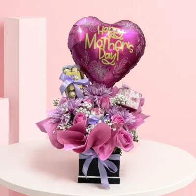 A luxurious arrangement of lavender chrysanthemums and roses with a scented candle, designed to brighten her space and heart.