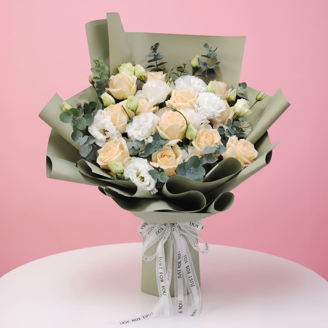 01 Bouquet of peach roses and white eustoma with eucalyptus wrapped in olive green paper.