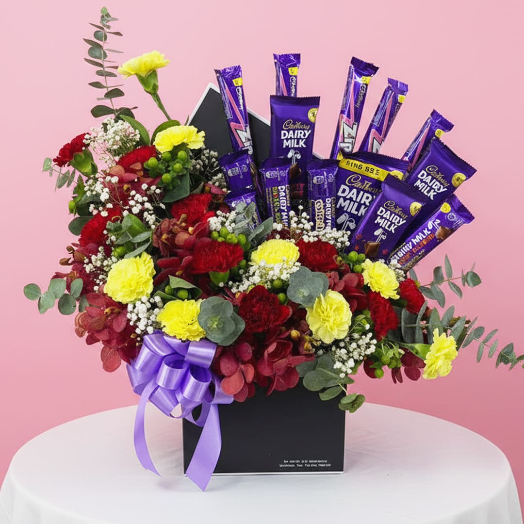 01 Cadbury and flower gift box with Cadbury Dairy Milk bars, red and yellow carnations, and purple ribbon.
