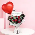 Red rose heart balloon bouquet with eucalyptus in white wrapping with black trim, finished with a red heart balloon and a “You Are My Love” wrap detail.