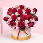 Rose Duo Box Deep with red roses and soft pink spray roses in a premium white-and-gold hatbox arrangement, finished with a satin ribbon.