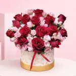 Rose Duo Box Deep with red roses and soft pink spray roses in a premium white-and-gold hatbox arrangement, finished with a satin ribbon.