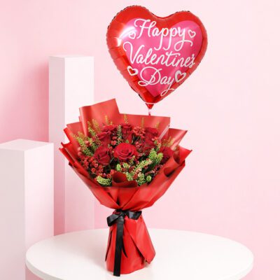 Red rose valentine balloon bouquet with seasonal fillers and greens in premium red wrapping, with a Happy Valentine’s Day heart balloon message