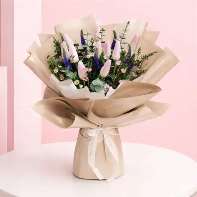 featuring pink tulip bouquet purple veronica flowers and eucalyptus foliage in premium beige wrapping, finished with an elegant ribbon bow.