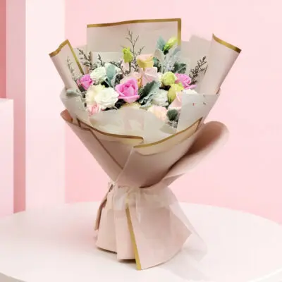 Pastel roses, seasonal blooms and greenery in premium cream wrapping with gold accents