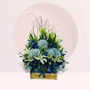 A blue and white floral arrangement displayed in a rustic wooden box.