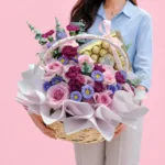 Freshly arranged bouquet of roses, dianthus, and daisies with eucalyptus stems, designed in a soft, flowing style with a light and organic feel.