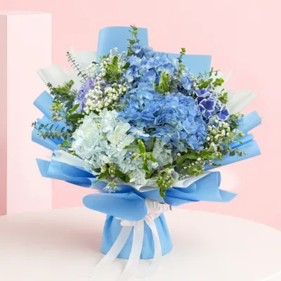 Hydrangea Breeze Bouquet featuring fresh hydrangeas, baby’s breath, and eucalyptus arranged in a soft, airy, and elegant floral design.