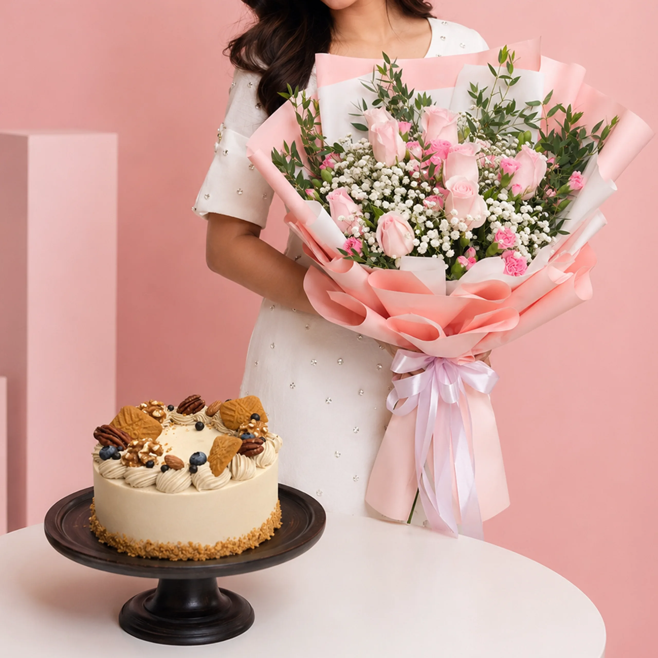 sweet-bouquet-walnut-cake-combo Sweet Bouquet Walnut Cake Combo featuring pink roses, pink spray carnations, gypsophila, and ruscus leaves paired with a Coffee & Walnut cake made with peanut cream and walnuts.