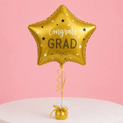 A star-shaped golden balloon with a 'Congrats Grad' printed text