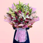 Signature Lily & Rose Bouquet featuring fresh lilies, roses, statice, spray carnations, baby’s breath, and eucalyptus arranged in an elegant floral design.