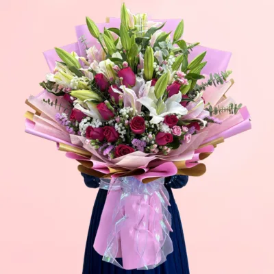 Signature Lily & Rose Bouquet featuring fresh lilies, roses, statice, spray carnations, baby’s breath, and eucalyptus arranged in an elegant floral design.